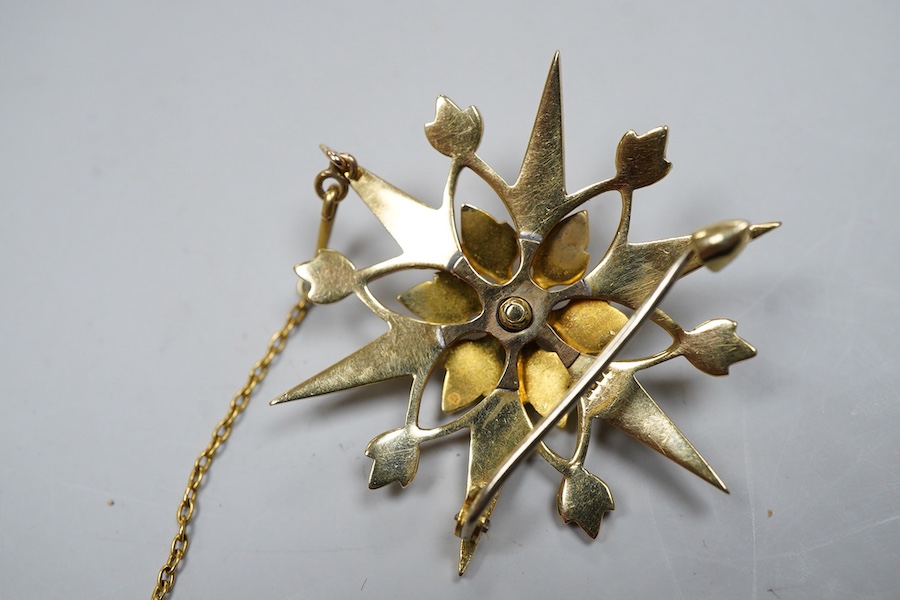 An Edwardian seed pearl brooch, early 20th century, designed as a snowflake, set with split seed pearls, mounted in gold, length 3.7cm, stamped 15CT, pearls untested, Condition: good, minor wear